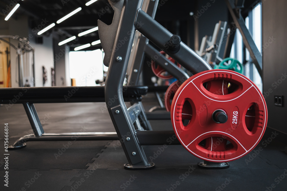 Fototapeta premium Bench with a barbell and discs on the rack to perform the barbell bench press in gym