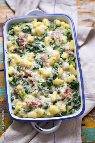 Gnocchi potato dumplings bake with spinach, broccoli, parma ham in rich cheese sauce