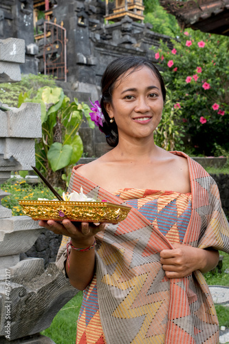 Portrait young woman with balinese face, wearing dress traditional Bali sarong in home temple.  photo