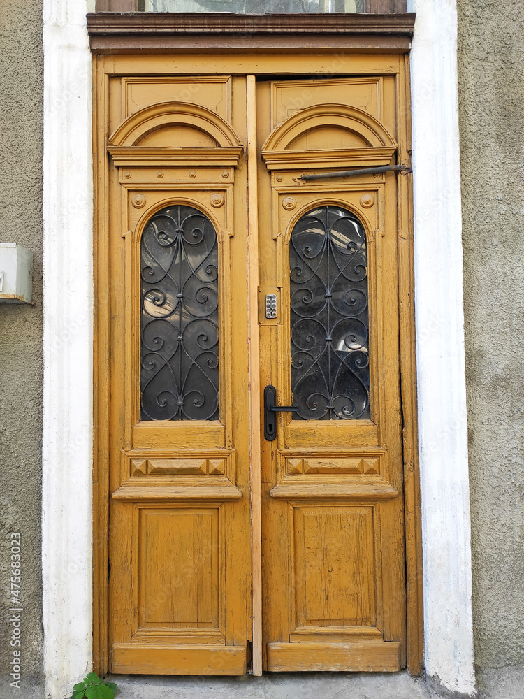 Old style door yellow color. Colorful exterior, wooden door.