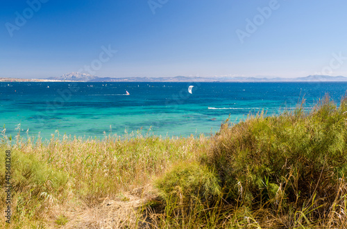 Beautiful seascape with blue sky and Atlantic ocean. A lot of kiteboarders trainig. Morocco and mount Jebel Musa on the background. Punta Paloma beach  Tarifa  Provence of Cadiz  Spain.