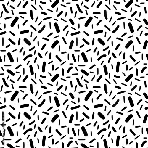 Seamless pattern. Black dashes in chaotic order on a white background. 