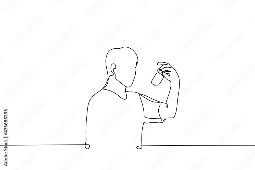 man stands looking at a jar of tablets or pills - one line drawing vector. concept of buying medicines, reading the composition of ingredients from medicines and supplements