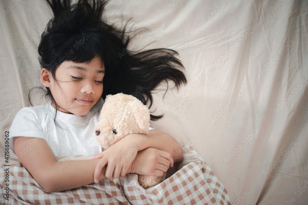 child little girl sleeps in the bed with a toy teddy bear child little girl sleeps in the bed with a toy teddy bear
