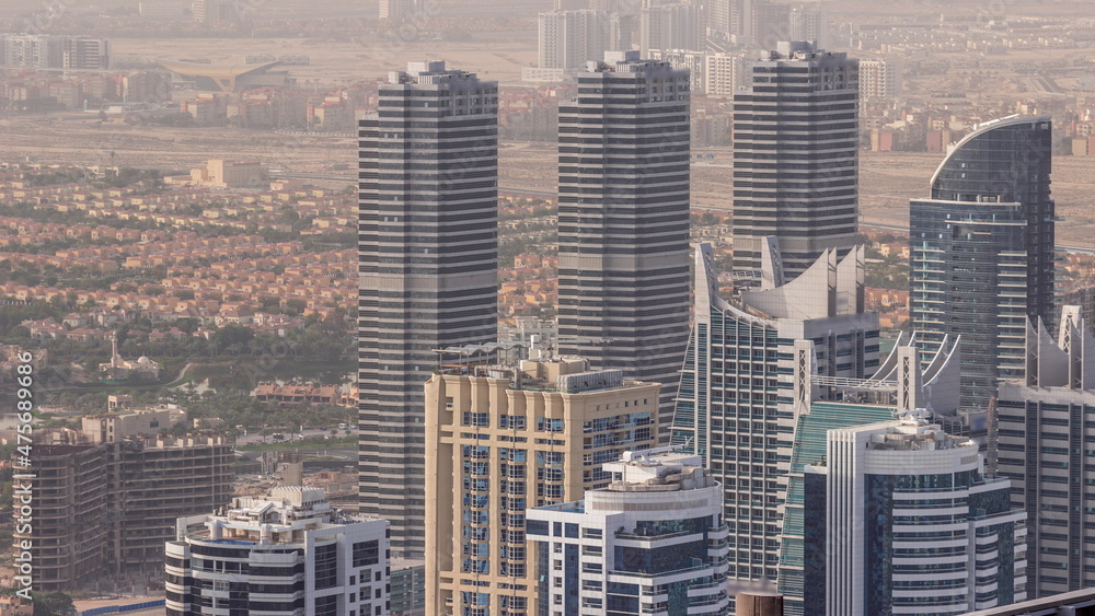 Jumeirah Lakes Towers district with many skyscrapers along Sheikh Zayed Road aerial timelapse.