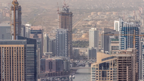 Skyline panoramic view of Dubai Marina showing an artificial canal surrounded by skyscrapers along shoreline timelapse. DUBAI, UAE