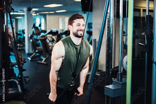 pulldown exercise at lat pull machine with rope handle © Shotmedia