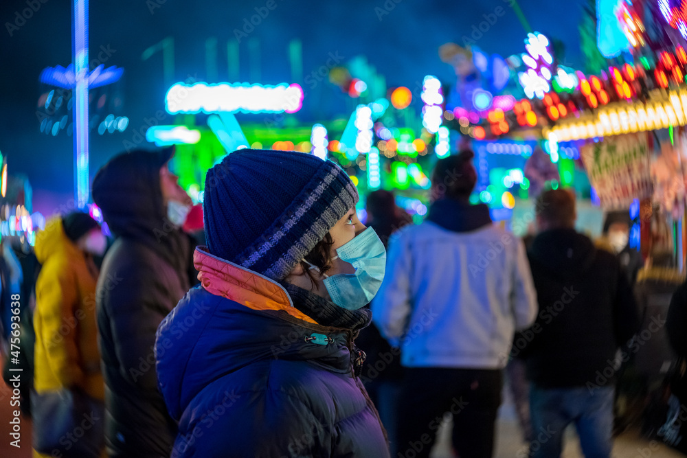 A teenager at a Christmas market during COVID-19 pandemic restrictions.