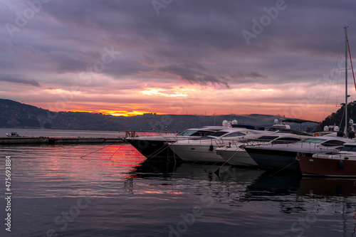 view of sailboats and yachts moored in the marina of  Istanbul, Turkey. Sunrise with colorful clouds and sky © Birol