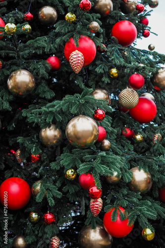 Beautifully decorated Christmas tree on the street. Tree branches with red and gold balls at the Christmas market.