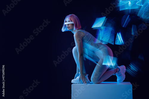 Woman in futuristic costume. Female in modern VR glasses interacting with network while having virtual reality experience. Augmented reality game, future technology, AI concept. VR. Neon blue light.