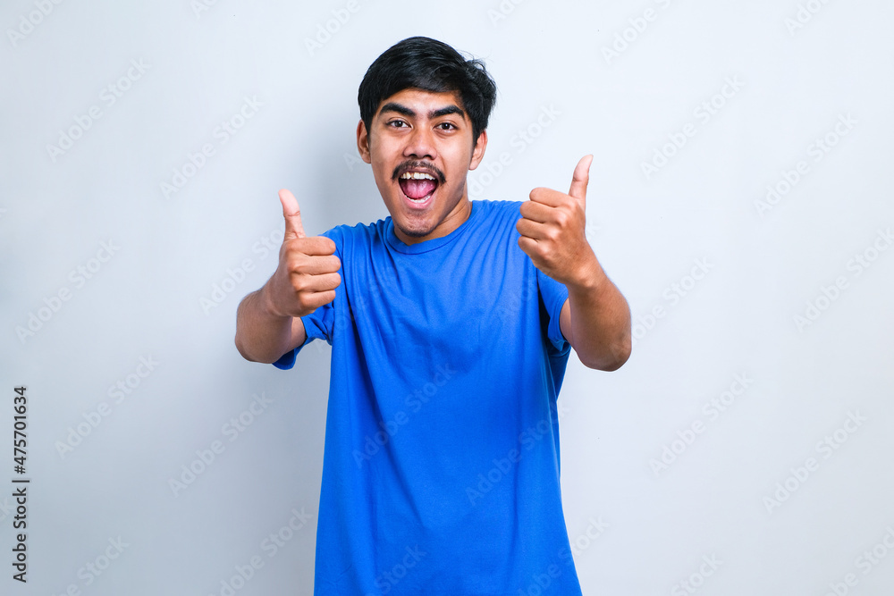 Asian man approving doing positive gesture with hand, thumbs up smiling and happy for success. Winner gesture. Asian man approving doing positive gesture with hand, thumbs up smiling and happy for success. Winner gesture.