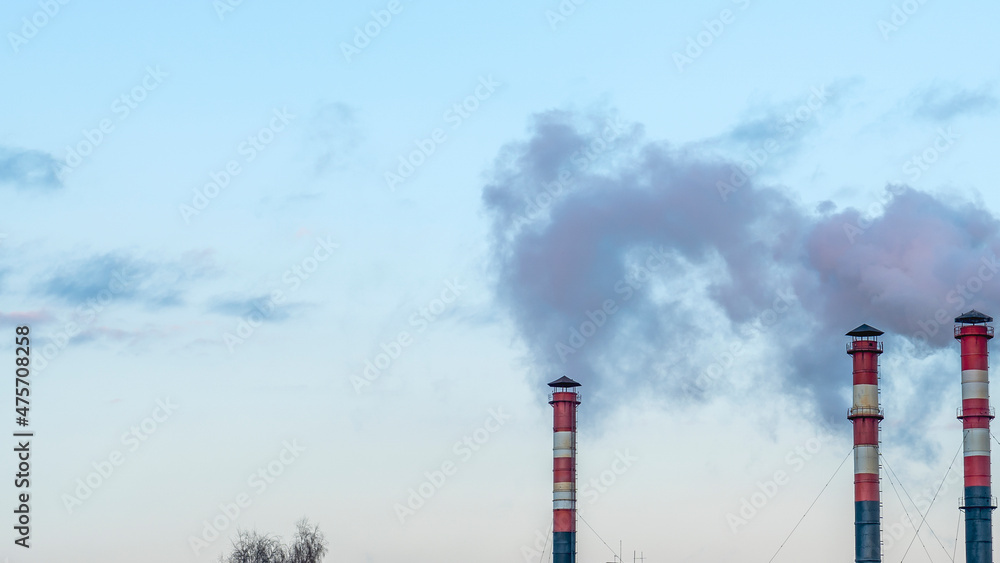 Smoking pipes from factories against a sunset sky. Close-up view of smoking factory chimney. Ecological problem. Smoking pipes from factories against a sunset sky. Close-up view of smoking factory chimney. Ecological problem.