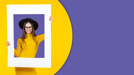 Foto auf Acrylglas Pantone 2022 very peri woman is smiling. Young girl is holding frame. Attractive woman in stylish trendy background. Portrait of girl surrounded by colors of year. Copy space on Very Peri. Fashionable Very Peri portrait  © Grispb