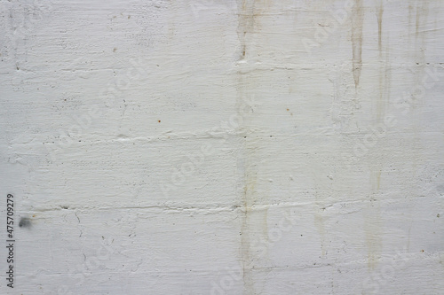 Old wall painted with white paint with the texture of a large brick. 