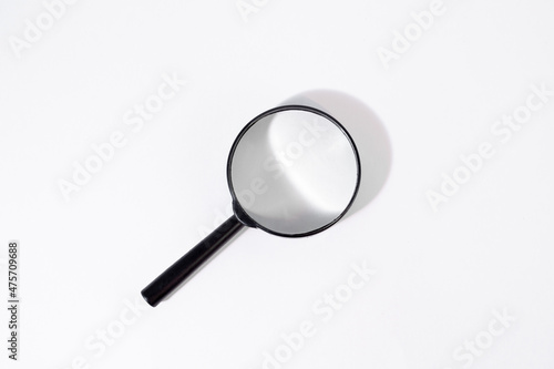 Magnifier with black frame lies on white isolated background