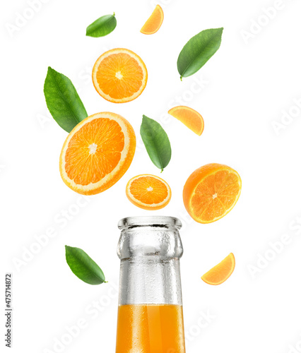 Orange juice bottle and Falling juicy oranges with green leaves isolated on transparent background. Flying defocusing slices of oranges. Applicable for fruit juice advertising