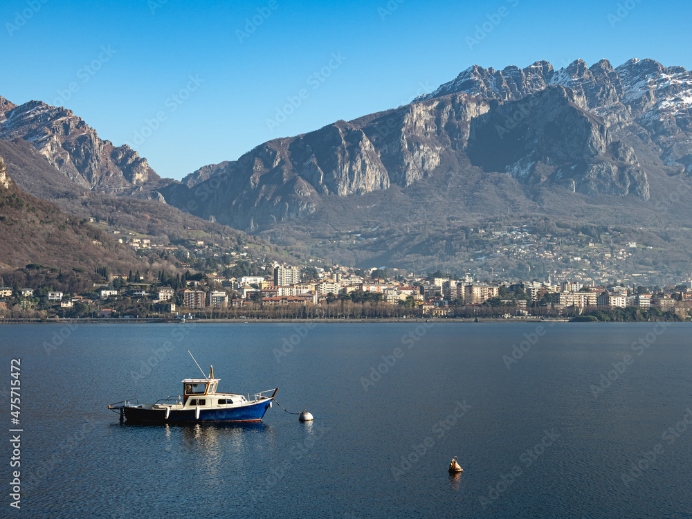 Small fishing boat moored in front of the city of Lecco, on Lake Como (Italy)