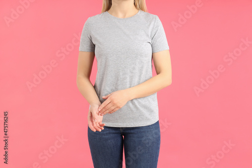 Woman in blank gray t-shirt on pink background