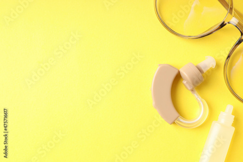 Concept of health care with hearing aid on yellow background