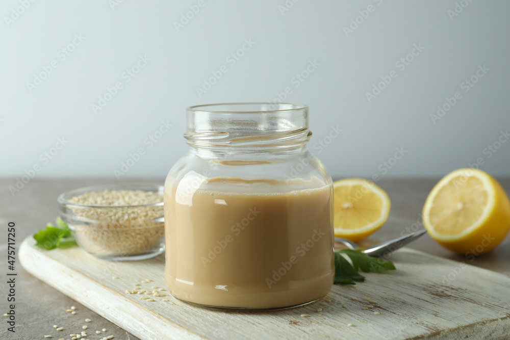 Concept of tasty food with tahini sauce on beige textured table Concept of tasty food with tahini sauce on beige textured table