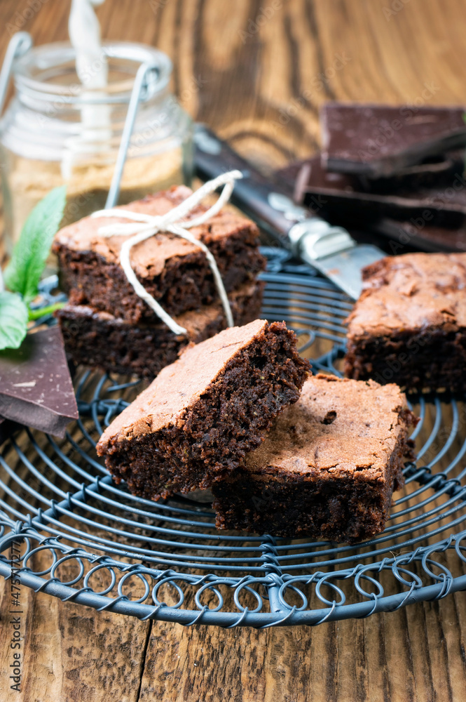Traditional backed American brownies served as close-up on a rustic cake plate on a wooden board Traditional backed American brownies served as close-up on a rustic cake plate on a wooden board