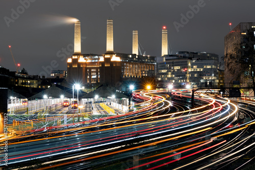 Light trails of passing trains heading in and out of London Victoria with Battersea Power Station in the background.