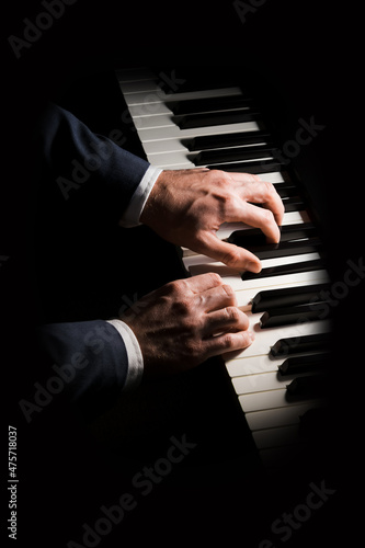 Fototapeta Pianist plays chord on piano with both hands