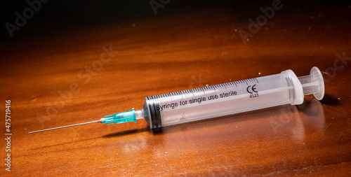 Syringe ready for vaccination on a wooden surface