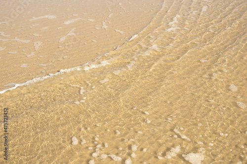 reflection of light in sea water on a background of yellow sand
