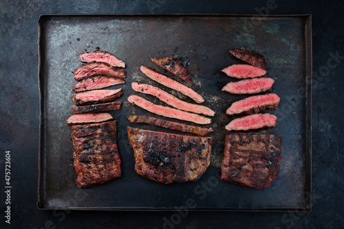 Traditional barbecue wagyu gourmet beef steaks served as top view on a rustic black board