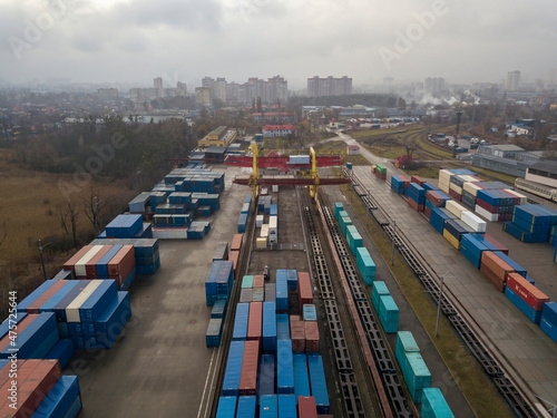 Multicolored freight containers at the railway customs. Aerial drone view.