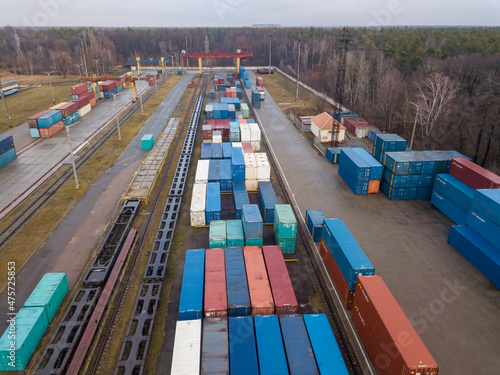 Multicolored freight containers at the railway customs. Aerial drone view.