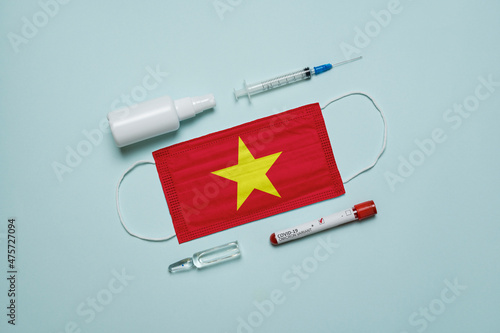 Blood tube for test detection of virus Covid-19 Omicron Variant with positive result, medicine mask with Vietnam flag superimposed and vaccine.  New Variant of the Covid-19 Omicron