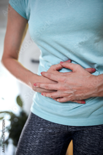 Woman with hip - stomach pain at home.