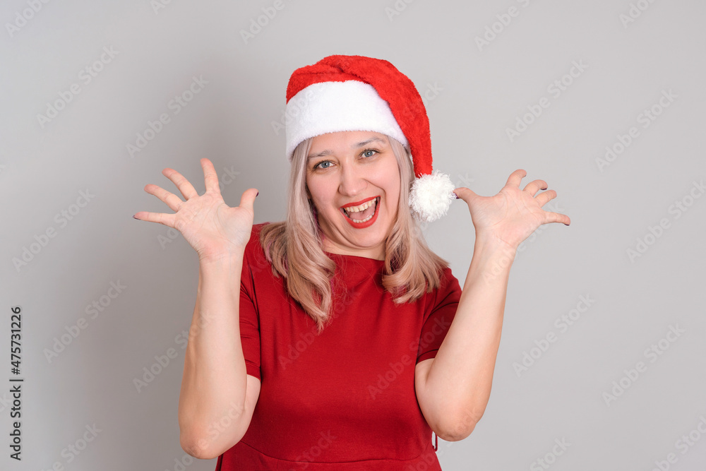 A joyful woman in a Santa hat with her palms up A joyful woman in a Santa hat with her palms up