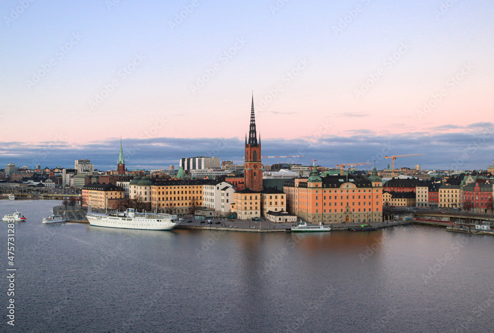 Skyline view of Riddarholmen island by the water at dusk, in Stockholm, Sweden.
