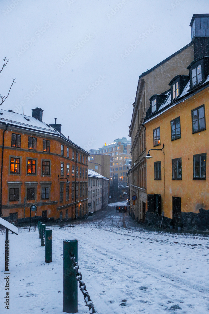Fototapeta premium Snowy Swedish street and buildings at sunset, Södermalm, Stockholm, Sweden.