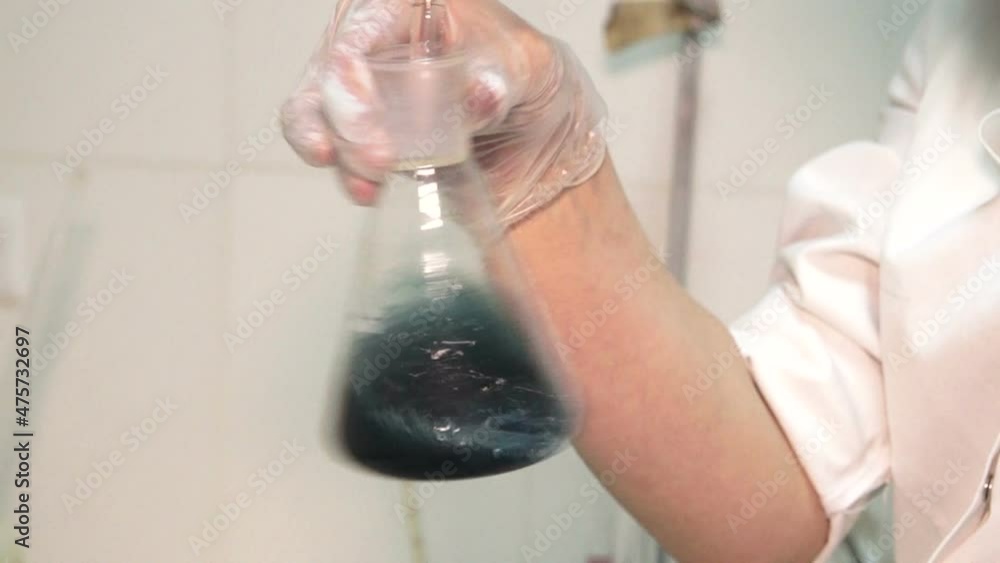 Laboratory testing of wine. Scientist pouring wine product liquid into