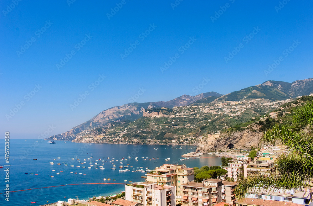 Naklejka premium View of the sunny scenic coastline, harbour, boats and sea off of Maiori, Amalfi coast, Italy.