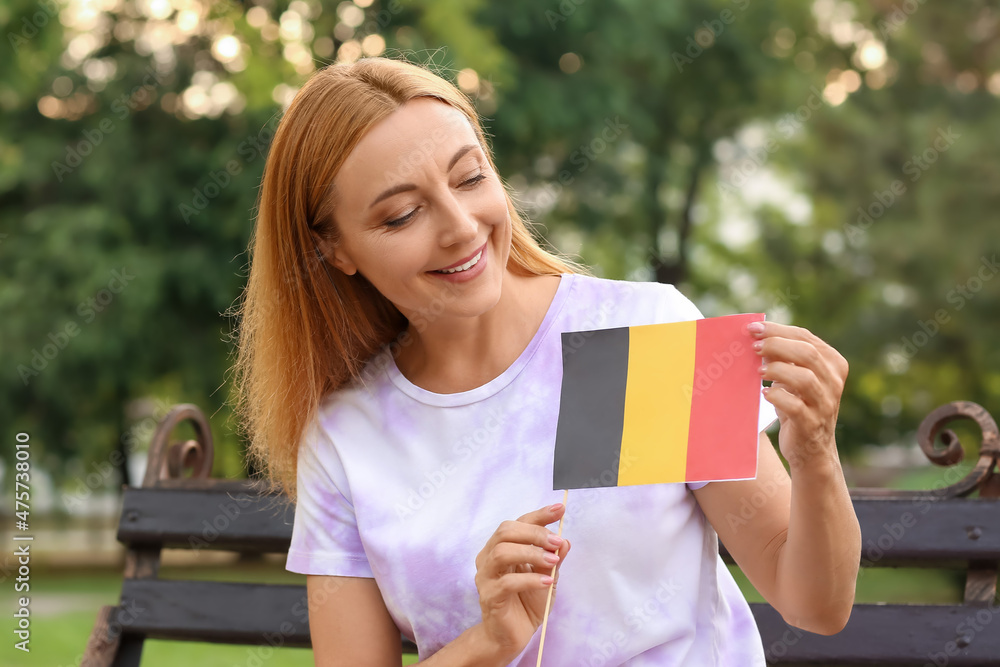 Fototapeta premium Mature woman with flag of Belgium sitting on bench in park
