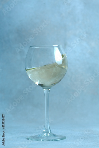 champagne flute with splash on the sand against the background of the old wall