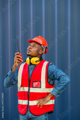 Hand Foreman holding walkie- talkie for control working at Container cargo site. Handheld walkie talkie for outdoor