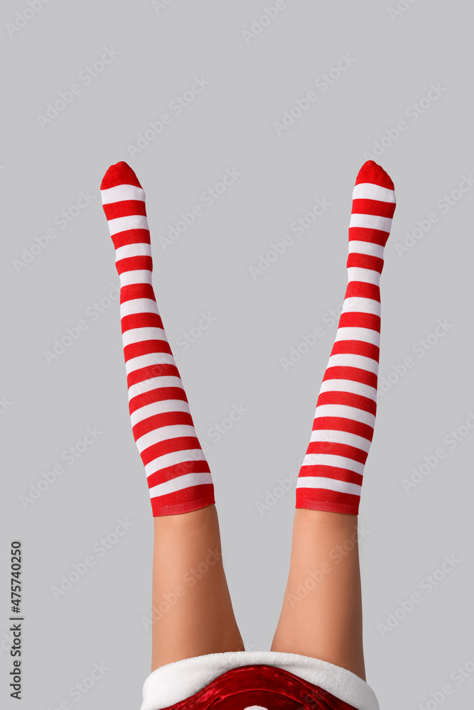 Legs of sexy young woman in Christmas stockings on light background Legs of sexy young woman in Christmas stockings on light background