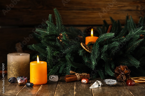 Composition with glowing candles and crystals on wooden background. Winter solstice