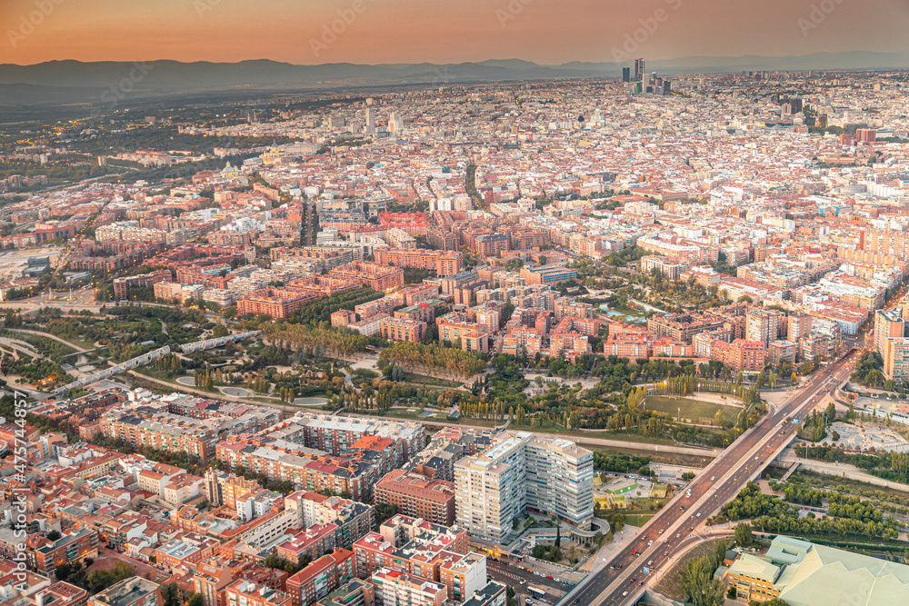 Aerial views of the city of Madrid during sunset on a clear day, being able to observe the five towers, the financial center, the Almudena cathedral, the Royal Palace and Madrid Río