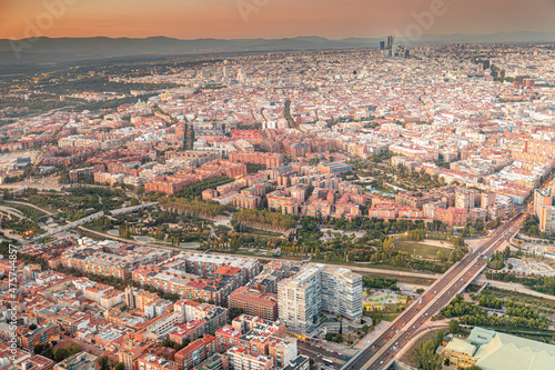 Aerial views of the city of Madrid during sunset on a clear day, being able to observe the five towers, the financial center, the Almudena cathedral, the Royal Palace and Madrid Río