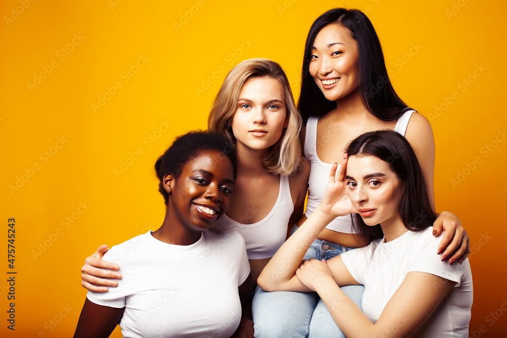 diverse multi nation girls group, teenage friends company cheerful having fun, happy smiling, cute posing on yellow background, lifestyle people concept, african-american, asian and caucasian