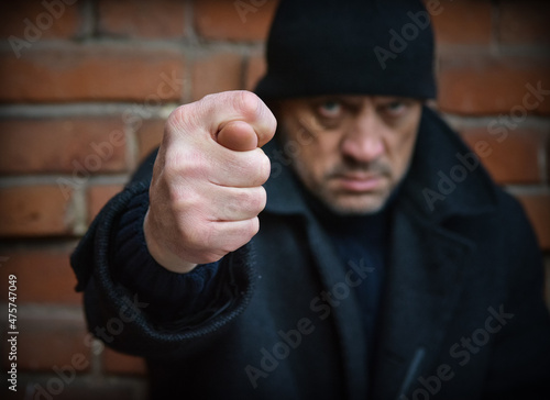 Close-up hand shows fig sign. The rude man shows an offensive hand gesture. photo