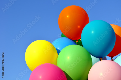 bunch of multicolored balloons in the city festival on clear blue sky background
